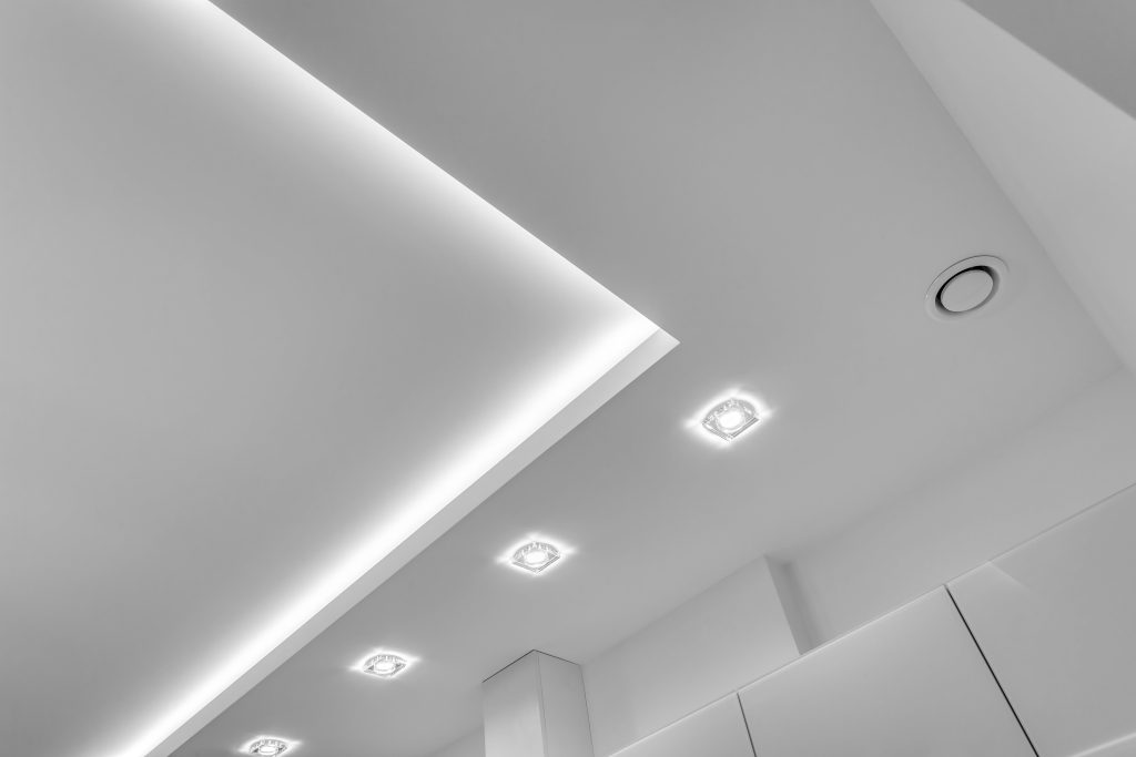 suspended-ceiling-with-halogen-spots-lamps-drywall-construction-empty-room-apartment-house-stretch-ceiling-white-complex-shape (2)-min